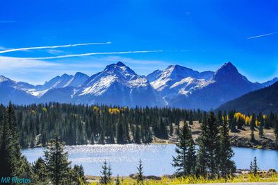 Scenic view of lake and mountains against blue sky