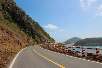 Road leading towards mountain against sky