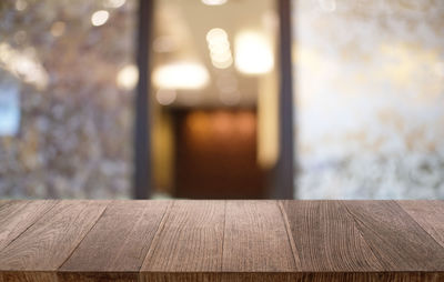 Close-up of wooden table with open door in background