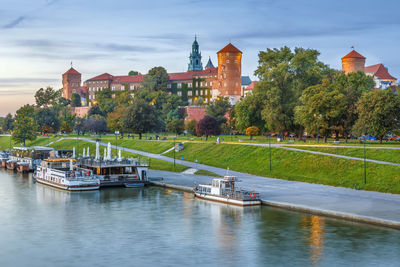 Scenic view of river by buildings against sky