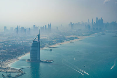 Aerial view of buildings in city against sky