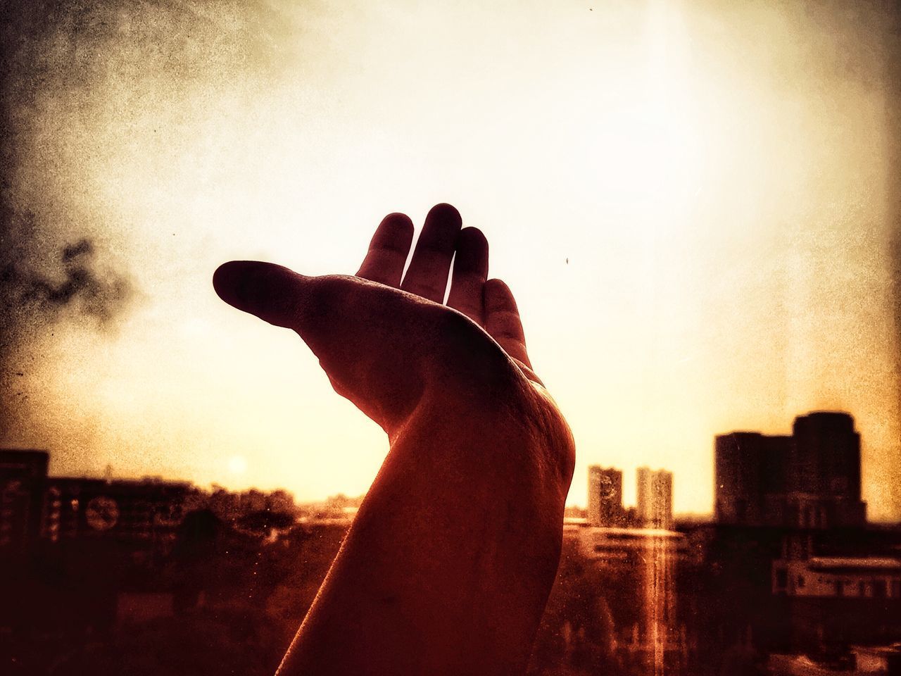 CLOSE-UP OF SILHOUETTE HAND AGAINST SKY