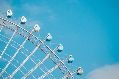 Low angle view of ferris wheel against blue sky