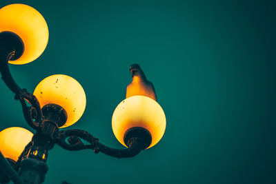 Low angle view of illuminated street light against sky