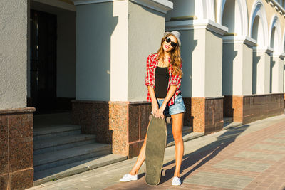 Portrait of woman standing against building