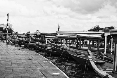 Boats moored at harbor against sky