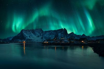 Scenic view of aurora borealis over snowcapped mountain