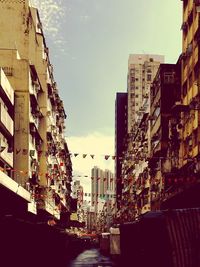 View of city street against cloudy sky