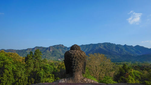 Statue on mountain against sky