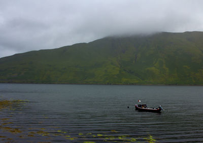 Scenic view of river by mountains against sky