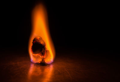 Close-up of fire on table against black background