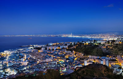 High angle view of townscape by sea against sky