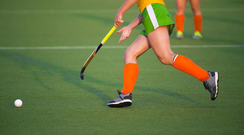 Low section of woman playing hockey in court