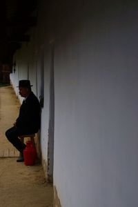 Side view of man sitting on floor