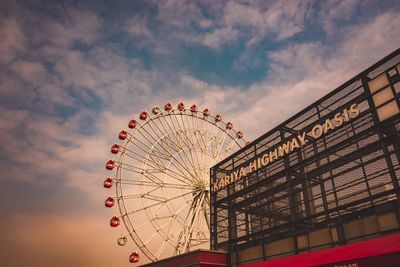 Low angle view of illuminated ferris wheel against sky