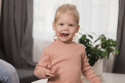 Portrait of cute girl sitting on bed at home