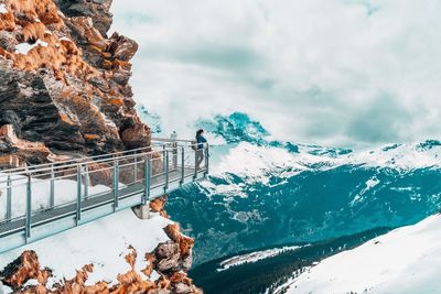 Woman looking at snowcapped mountains against sky