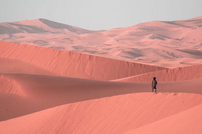 Person standing on sand dune in desert