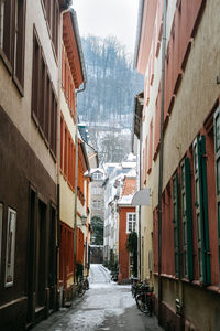 Empty alley amidst buildings in city during winter