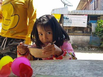 Portrait of cute girl eating noodles at outdoors