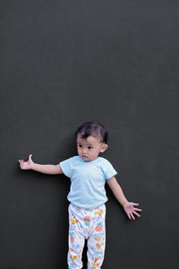 Cute girl standing against black background