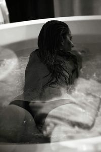 Woman sitting in bathtub