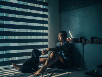 Young woman sitting on sofa at home