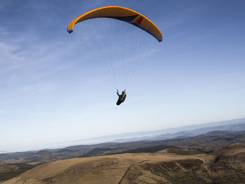 Person paragliding against sky