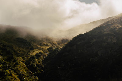 Scenic view of mountains against cloudy sky