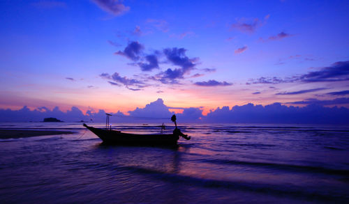 Amazing silhouette of fisherman yacht during breathtaking sunrise at cherating, pahang, malaysia.