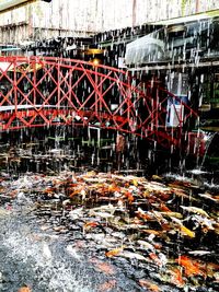 Graffiti on bridge over river against buildings