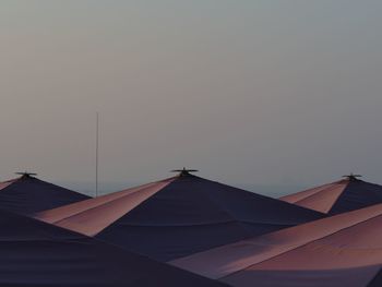 Low angle view of parasols against clear sky