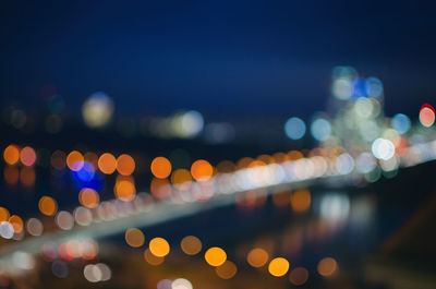 Defocused image of illuminated lights in city at night