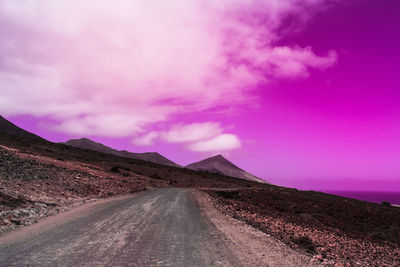 Road amidst land against sky
