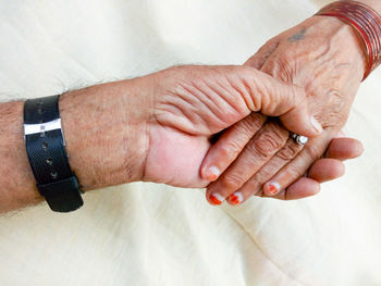 Cropped image of senior couple holding hands