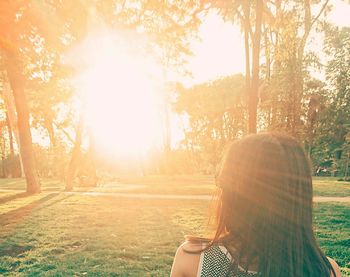 Woman in sunlight falling on field