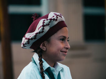 Close-up portrait of smiling young woman looking away