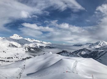 Scenic view of snowcapped mountains against cloudy sky