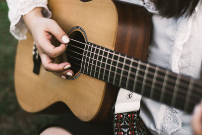 Midsection of woman playing guitar