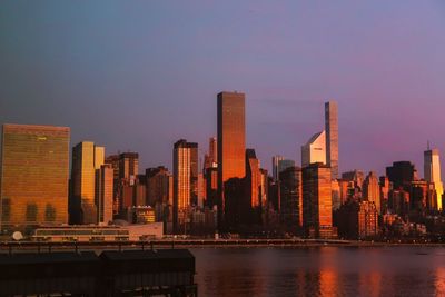 Modern buildings in city against sky during sunset