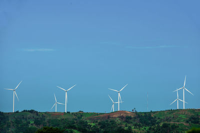 Wind turbines on land against sky