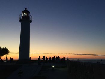 Low angle view of silhouette lighthouse against sky during sunset