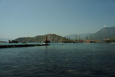 Boats in sea against clear sky