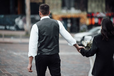 Rear view of people walking on street