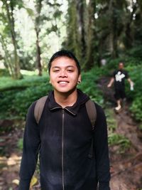 Portrait of a smiling young man in forest
