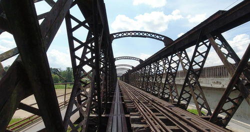 Bridge over railroad tracks against sky