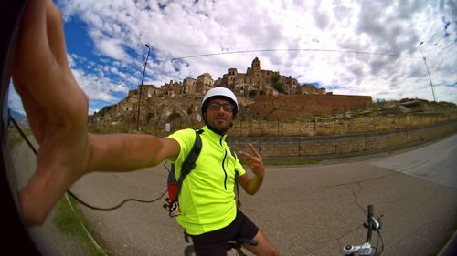 Portrait of man gesturing against old fort