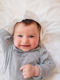 Portrait of cute baby lying on bed