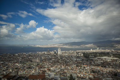 High angle view of townscape by sea against sky