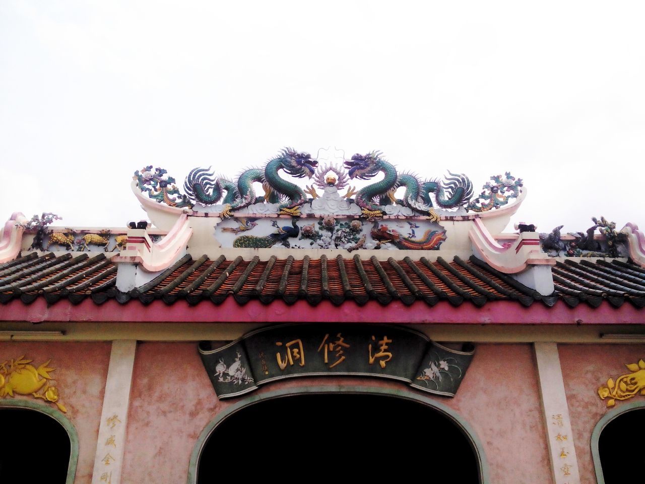 low angle view, architecture, built structure, art and craft, art, building exterior, creativity, sculpture, clear sky, statue, religion, place of worship, ornate, spirituality, carving - craft product, animal representation, roof, human representation, temple - building, sky